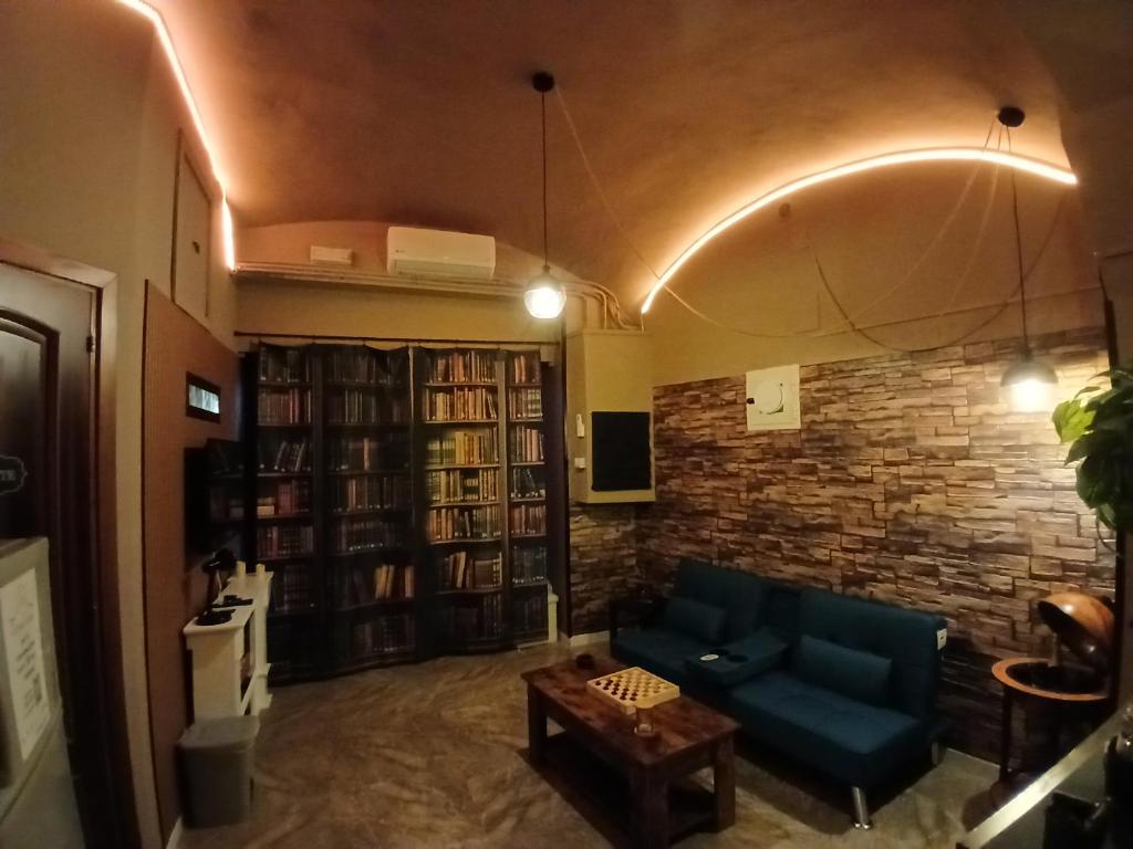 Il soggiorno de La Suite di Biky con soffitto a volta, libreria e divano blu